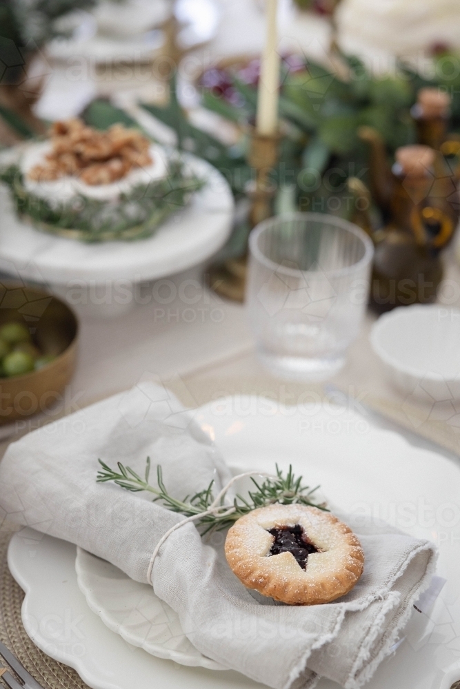 Decorated Christmas table with mince pie on plate - Australian Stock Image