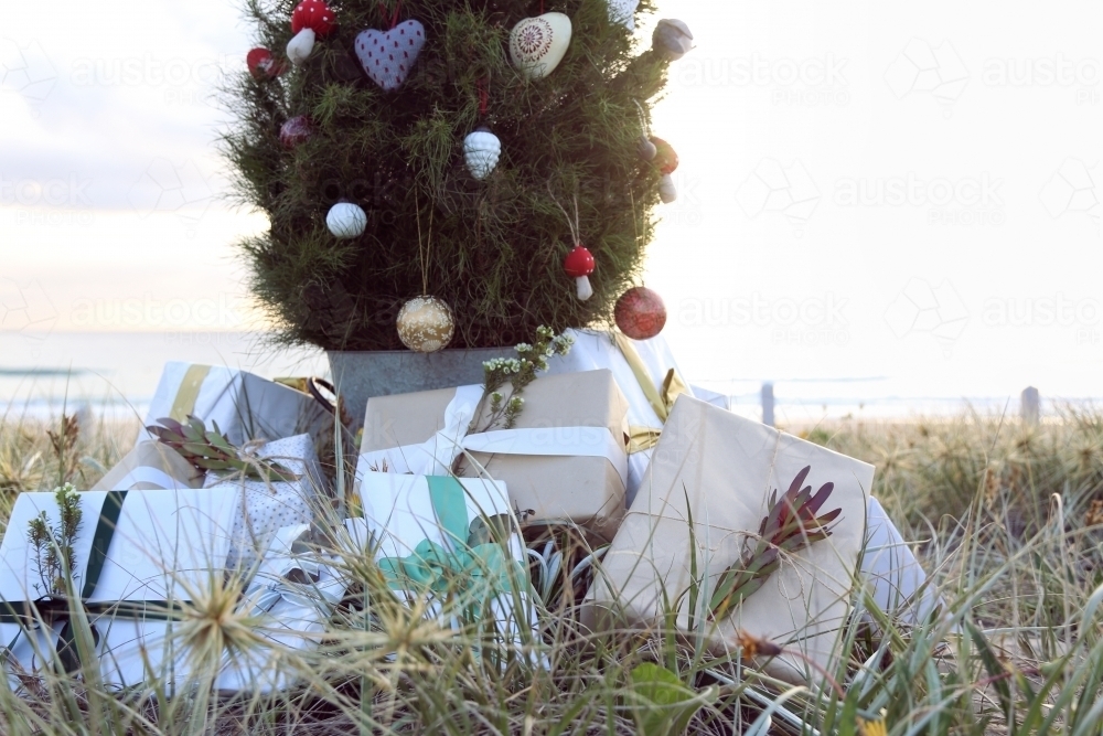 Decorated Christmas tree with presents with beach sunrise - Australian Stock Image