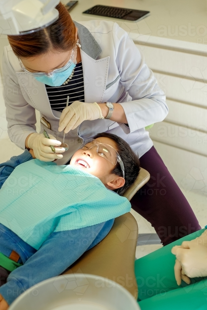 Dentist with a smiling kid patient - Australian Stock Image