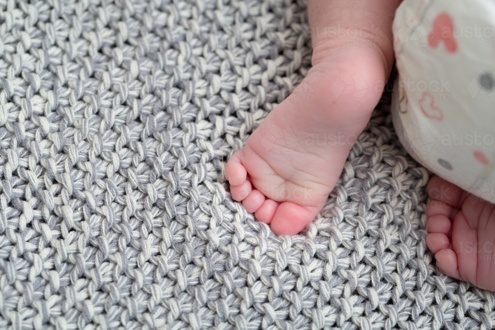 Detail of baby's feet and nappy on blanket - Australian Stock Image