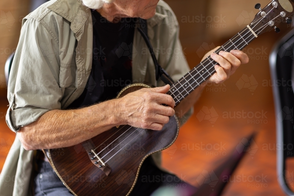 detail of older man playing a ukulele - Australian Stock Image