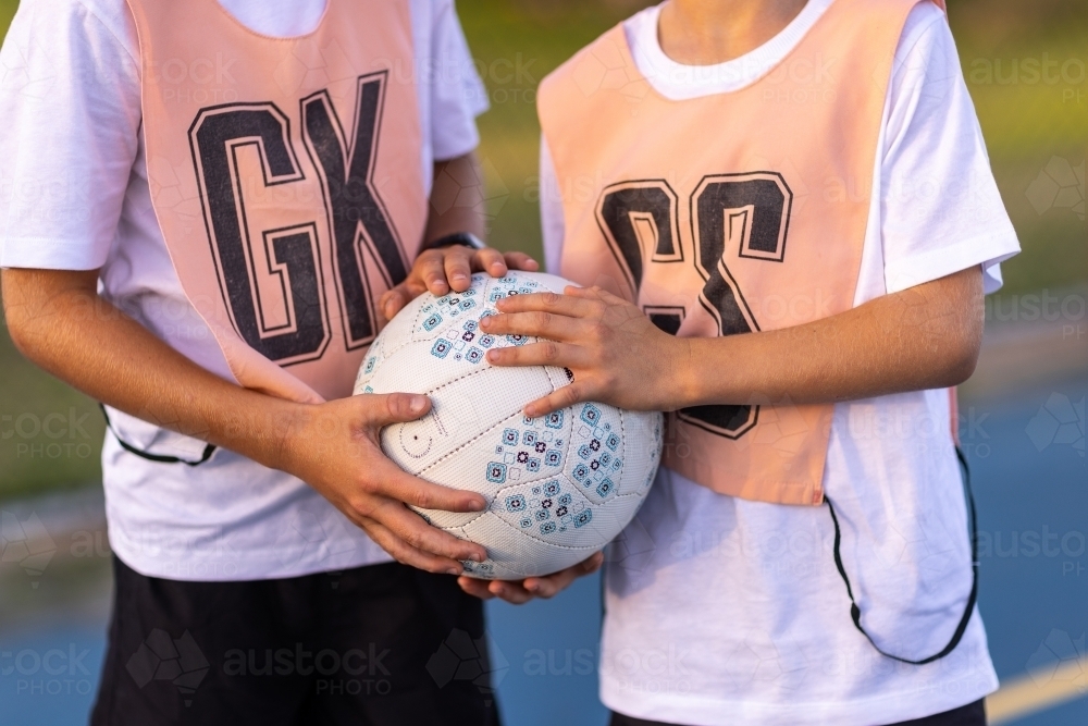 detail of two children holding netball - Australian Stock Image