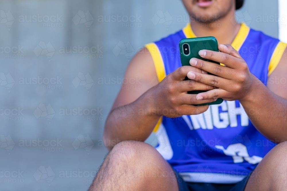 detail of young bloke looking at smartphone - Australian Stock Image