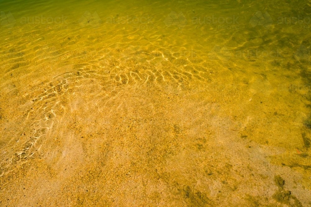 Detail shot of water with ripples and green and yellow tones - Australian Stock Image