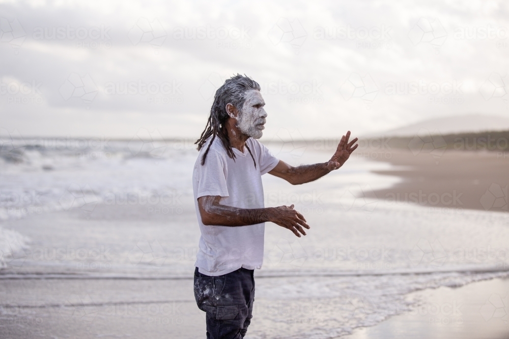 dharawal man at the beach explaining and pointing - Australian Stock Image