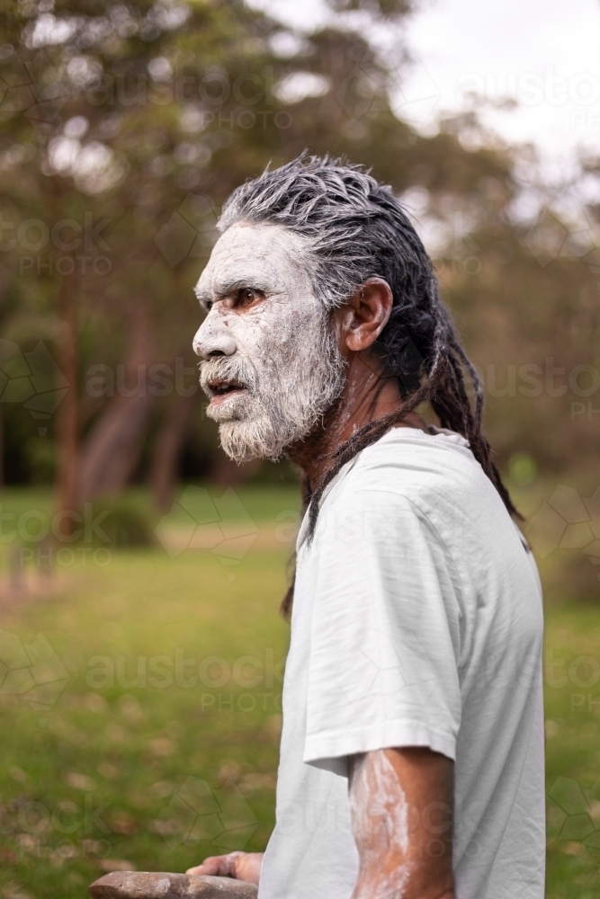 dharawal man wearing white body paint in conversation - Australian Stock Image