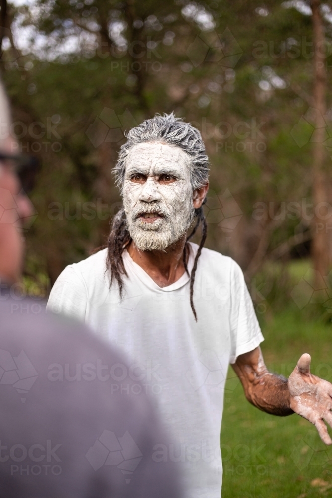 dharawal man wearing white body paint in conversation - Australian Stock Image