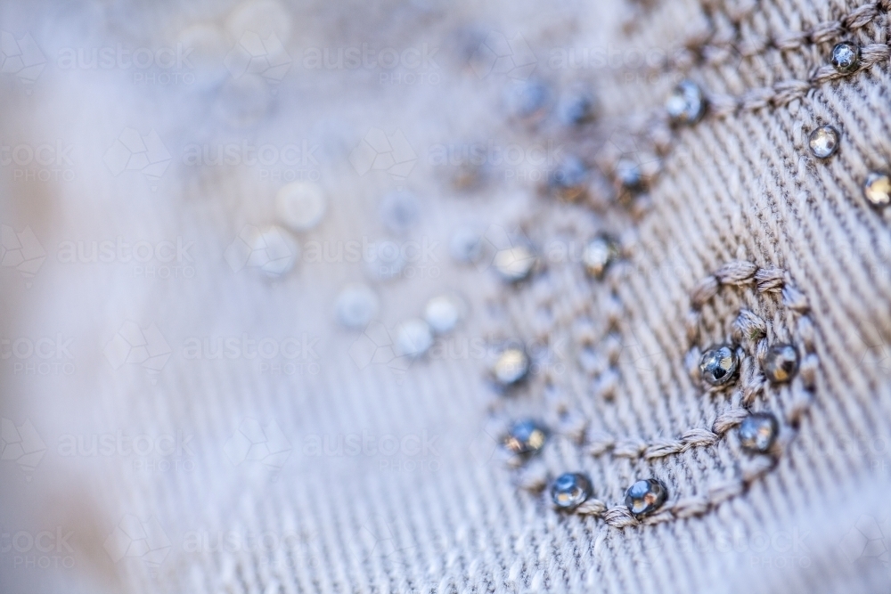 Diamante sparkles and threads making pattern on clothing - Australian Stock Image