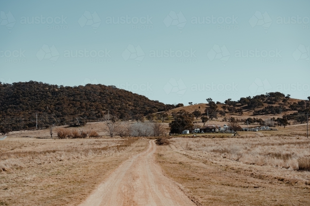 Dirt road driveway leading to a grassy rural property. - Australian Stock Image