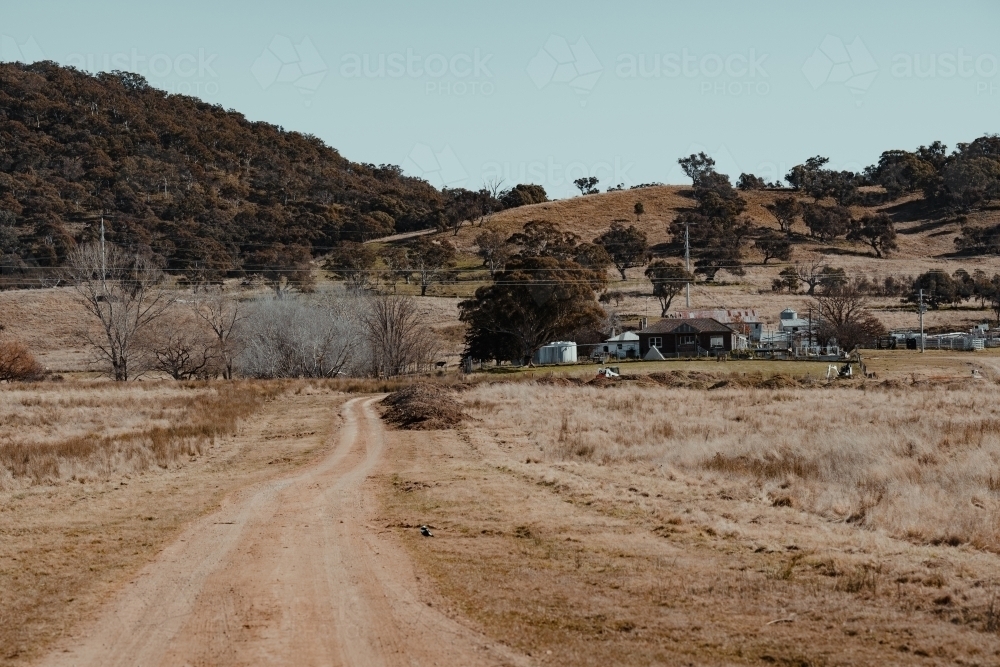 Dirt road driveway leading to a grassy rural property. - Australian Stock Image