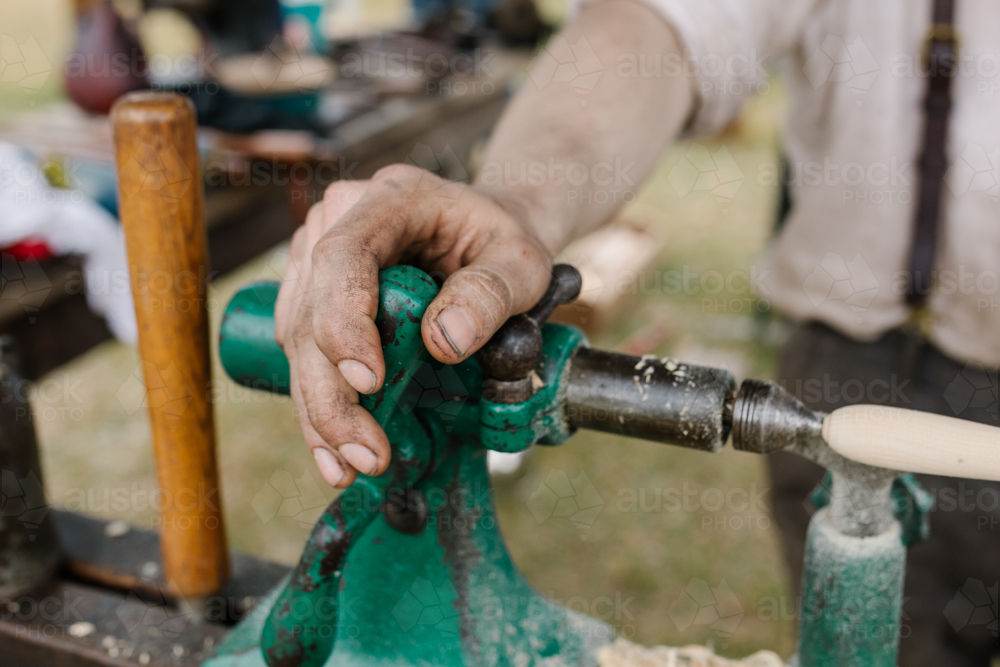 Dirty work hands on the wood lathe - Australian Stock Image