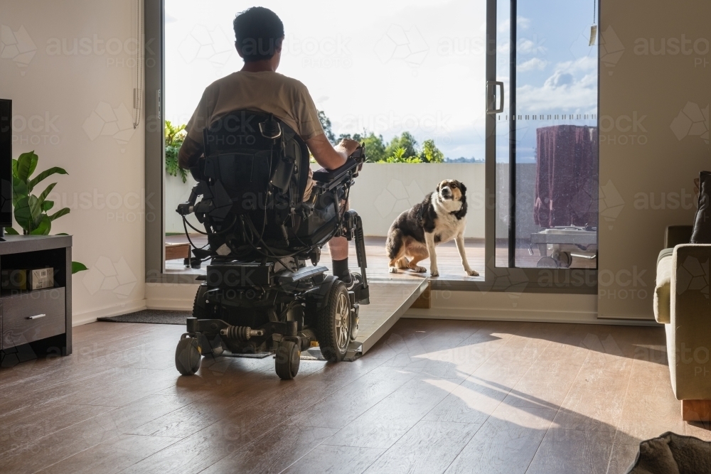 disabled man in wheelchair at home - Australian Stock Image