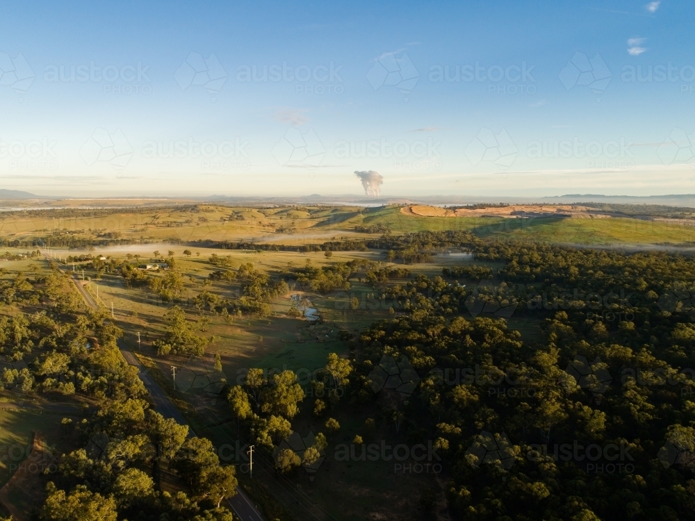 Distant open cut mine on the horizon and power station water vapor - Australian Stock Image