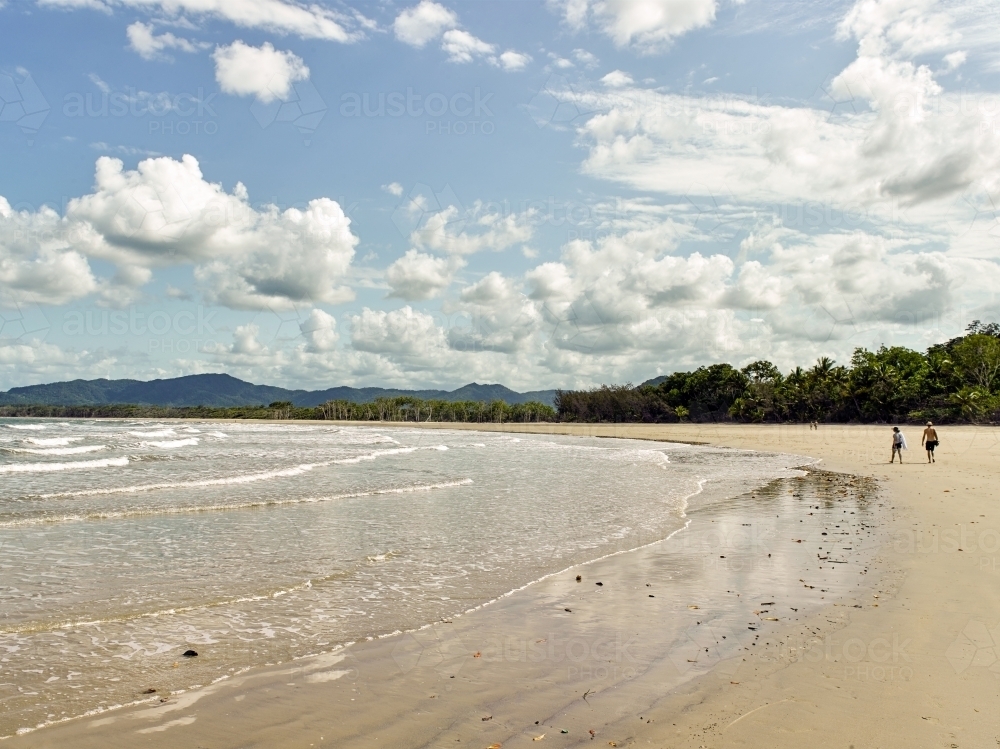 Distant people walking on a tropical beach - Australian Stock Image