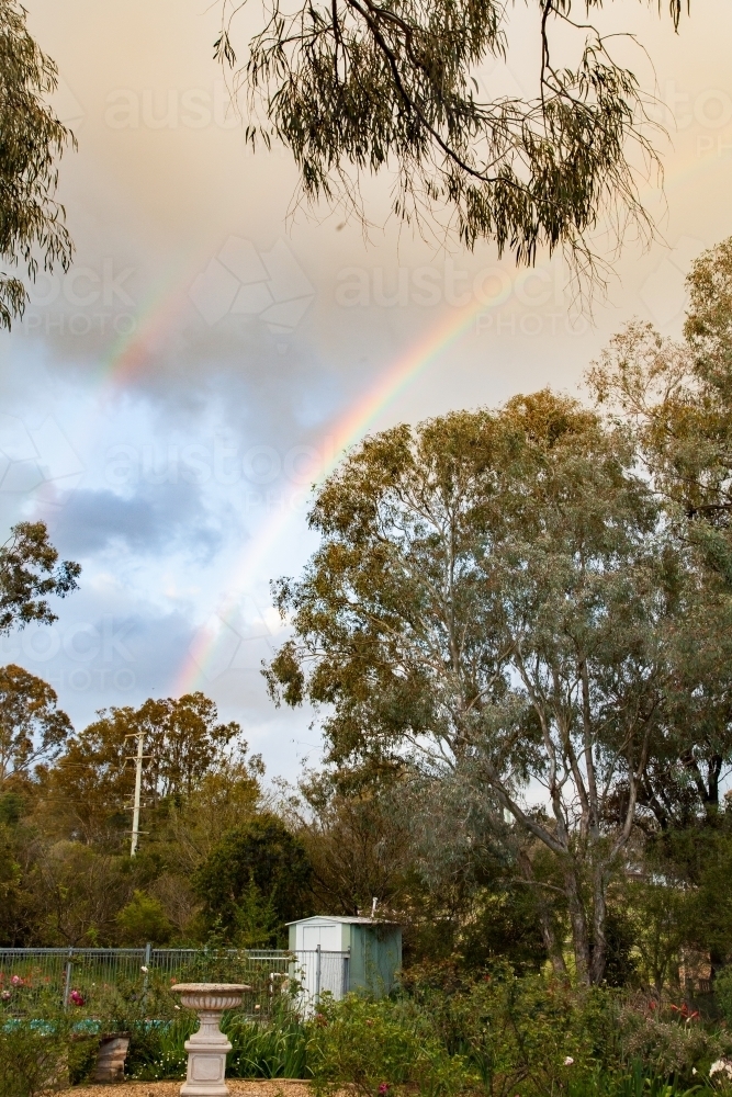 Double rainbow over garden in backyard - Australian Stock Image