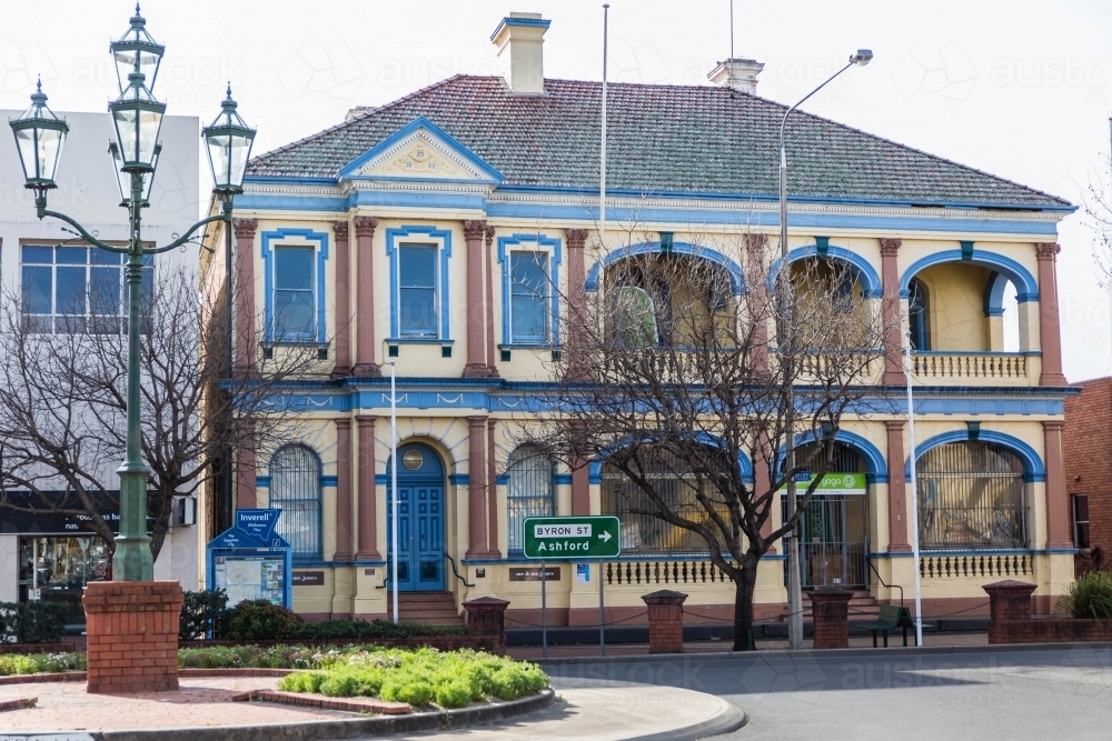 Double storey building with street sign and street lamp on roundabout - Australian Stock Image