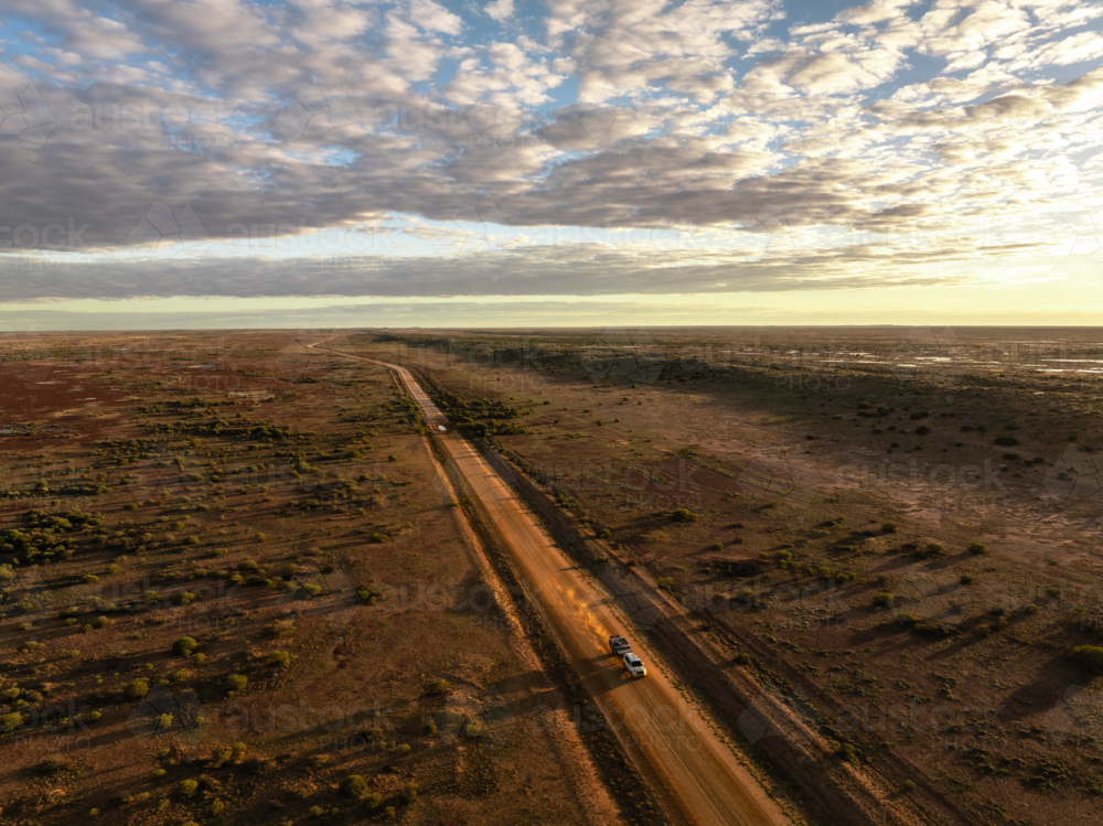 Driving along the Birdsville Track in the early morning golden hour light - Australian Stock Image