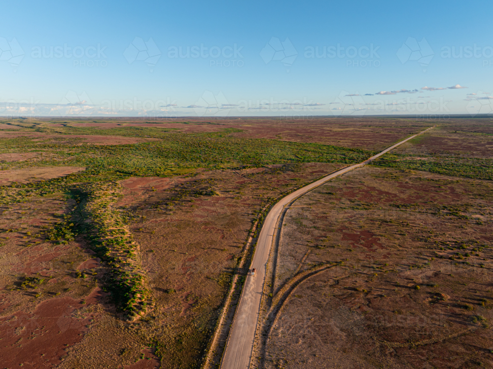 Driving along the Birdsville Track in the early morning golden hour light - Australian Stock Image