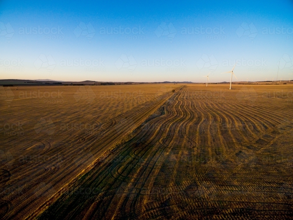 Drone shot of wind turbines in stubble paddock in late afternoon - Australian Stock Image