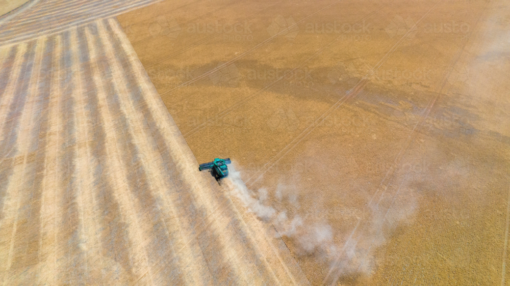 Dry-land farming machinery harvesting crop in farm paddock - Australian Stock Image