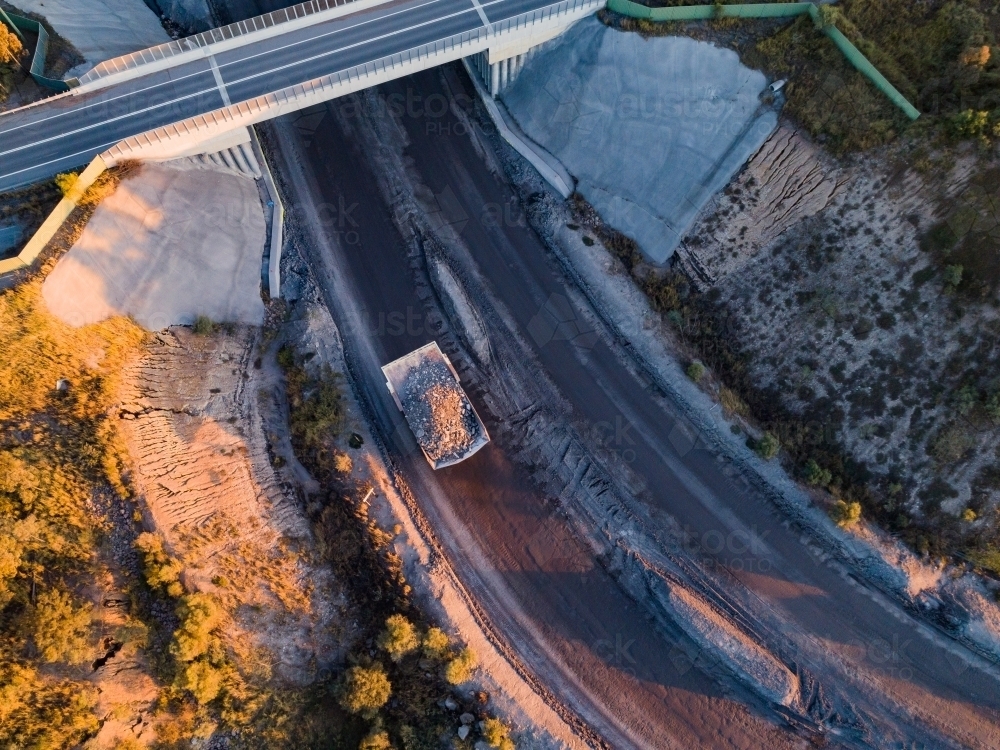 dump truck hauling dirt under bridge in open cut coal mine near Singleton - Australian Stock Image