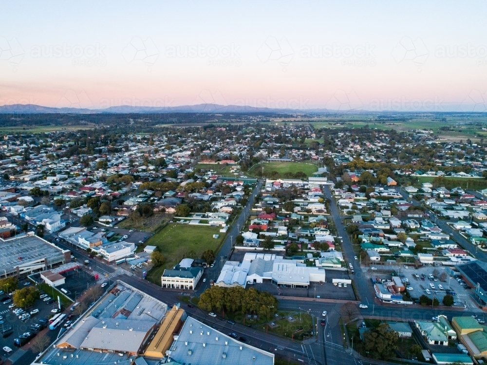 dusk light during blue hour over shops and streets to houses in town - Australian Stock Image