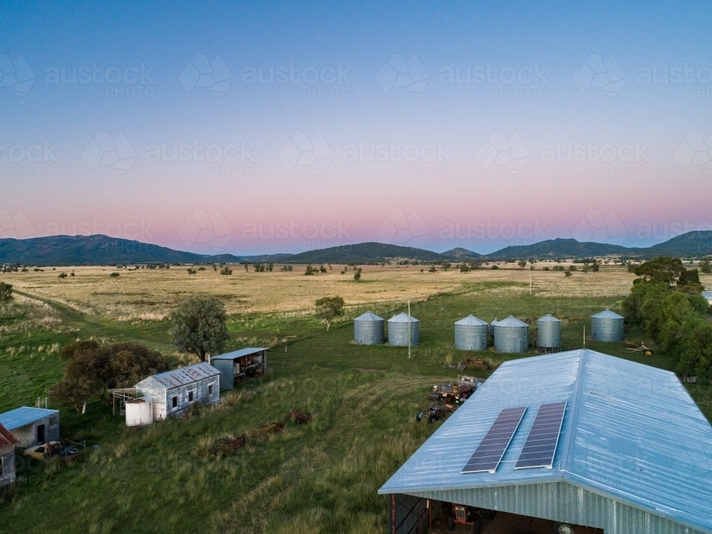 Dusk light on solar-powered farm shed harnessing renewable energy for sustainable agriculture - Australian Stock Image