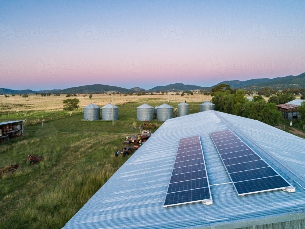 Dusk light on solar-powered farm shed harnessing renewable energy for sustainable agriculture - Australian Stock Image