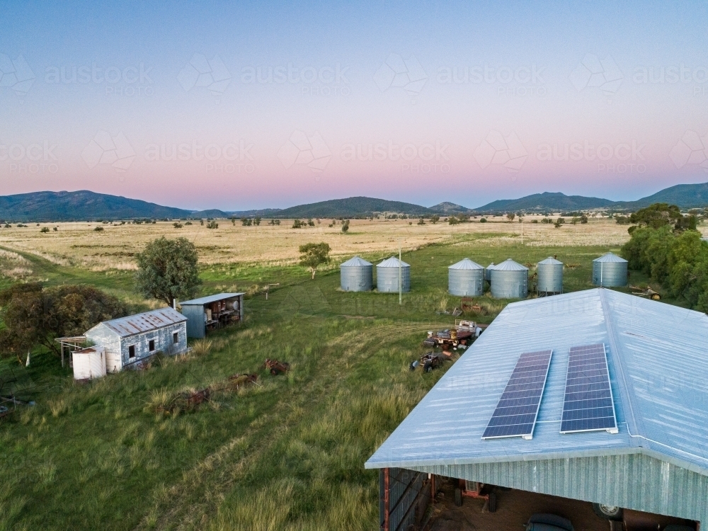 Dusk light on solar-powered farm shed harnessing renewable energy for sustainable agriculture - Australian Stock Image