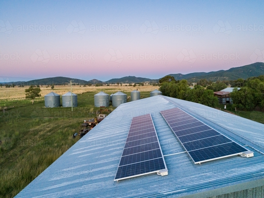 Dusk light on solar-powered farm shed harnessing renewable energy for sustainable agriculture - Australian Stock Image