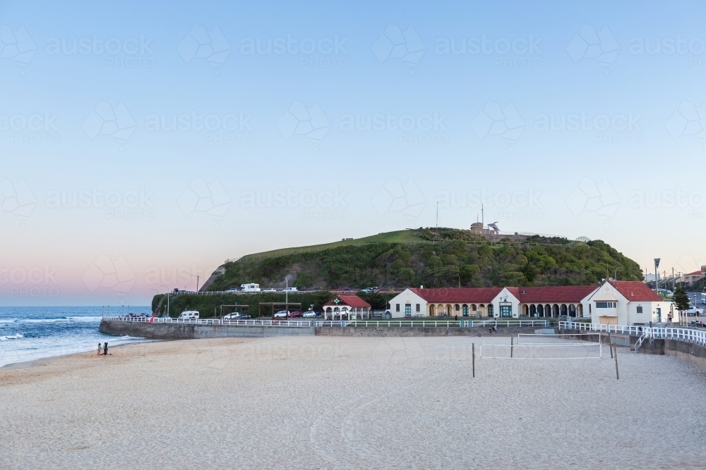 Dusk light over Nobbys Beach sand and surf pavilion buildings - Australian Stock Image