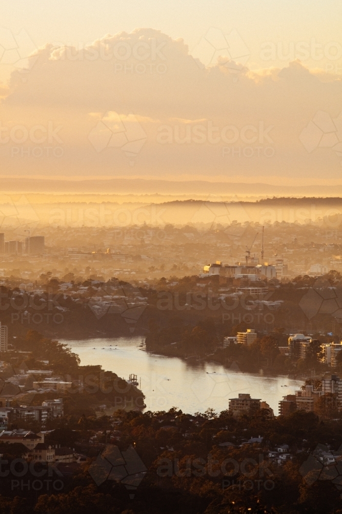 Early morning golden colours with some low lying fog over the Brisbane River and suburbs. - Australian Stock Image