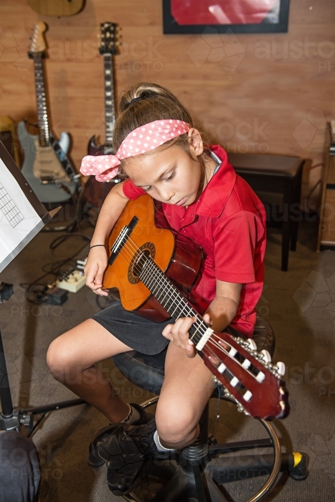 Eight year old girl learning guitar - Australian Stock Image