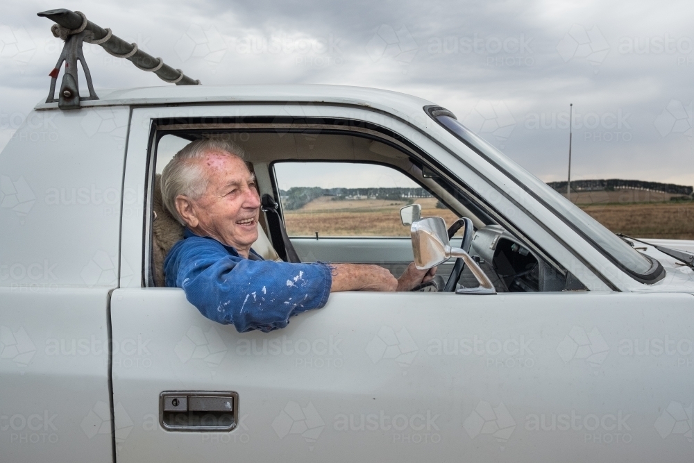 Elderly man driving his ute in the countryside. - Australian Stock Image