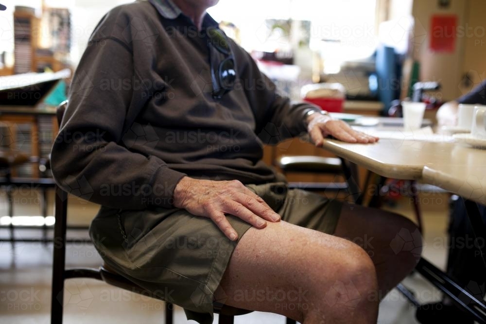 Elderly man sitting at table in aged care home - Australian Stock Image