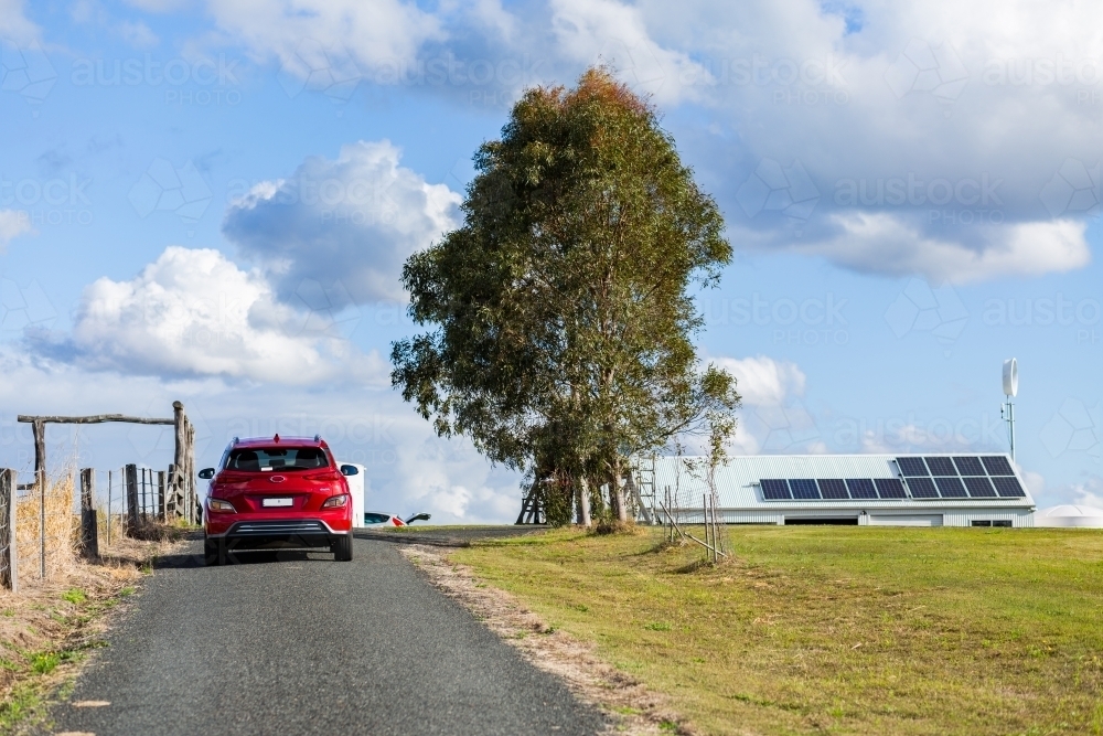 electric car driving up driveway to off grid property - Australian Stock Image