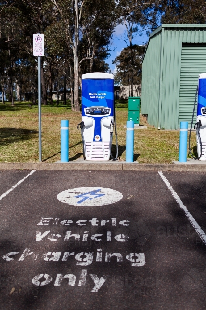 Electric vehicle charging only sign in carpark EV power plug station - Australian Stock Image
