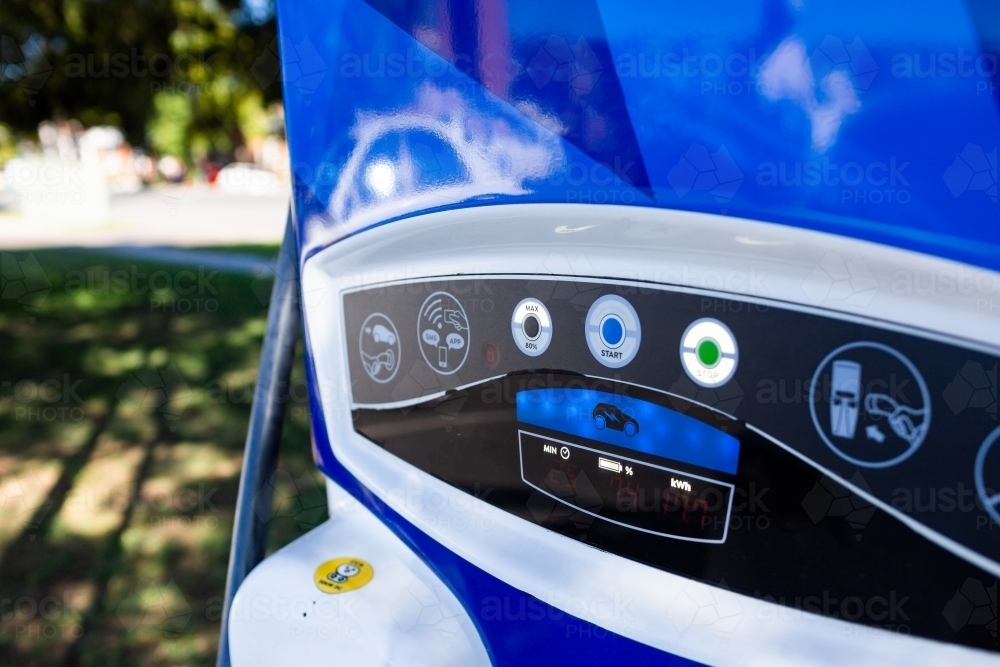 Electric vehicle charging station with car plugged in filling up ev batttery - Australian Stock Image