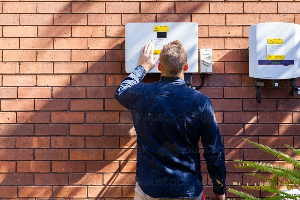 Electrician installing solar power connection to house - Australian Stock Image