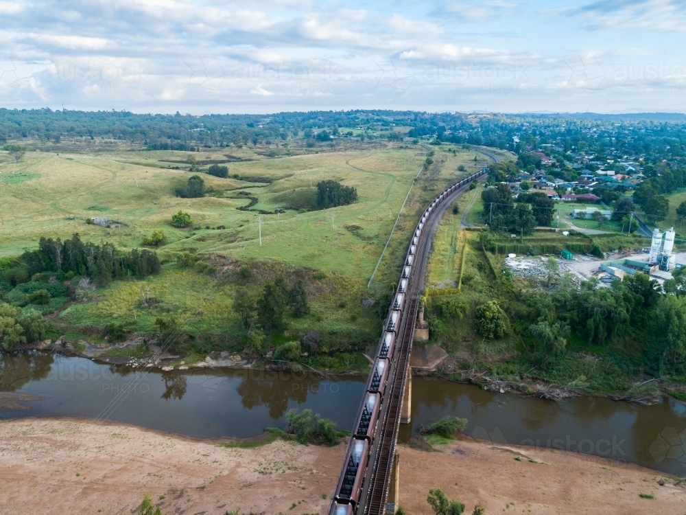 empty coal train travelling on railway beside country town of Singleton - Australian Stock Image