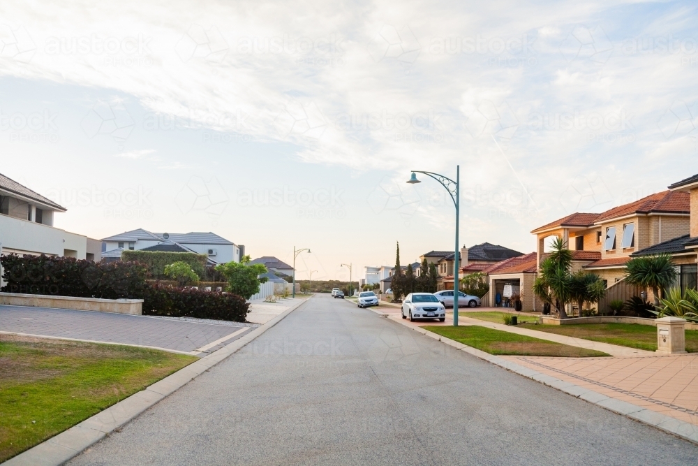 Empty road with neat houses along it in coastal suburb - Australian Stock Image