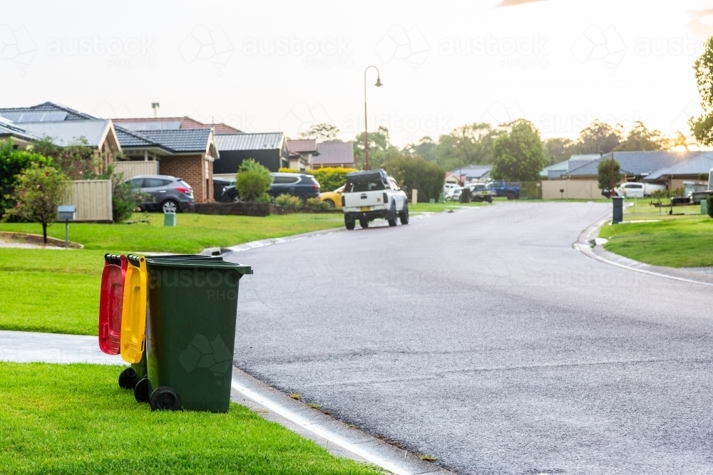 Empty rubbish and recycling bin sitting at bed in suburban road after rain - Australian Stock Image