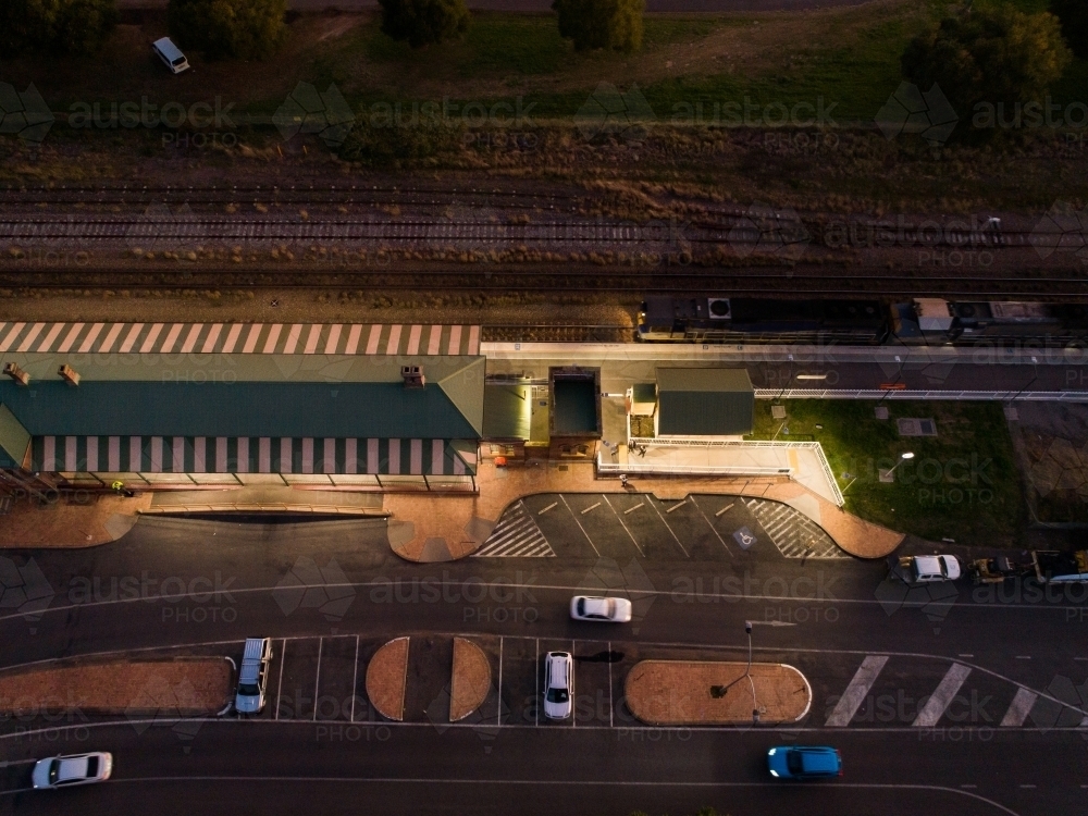 Engine of freight train passing station seen from above in late evening - Australian Stock Image