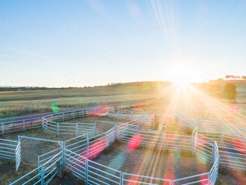 Evening sunlight shining over cattle ramp and stock yards on farm - Australian Stock Image