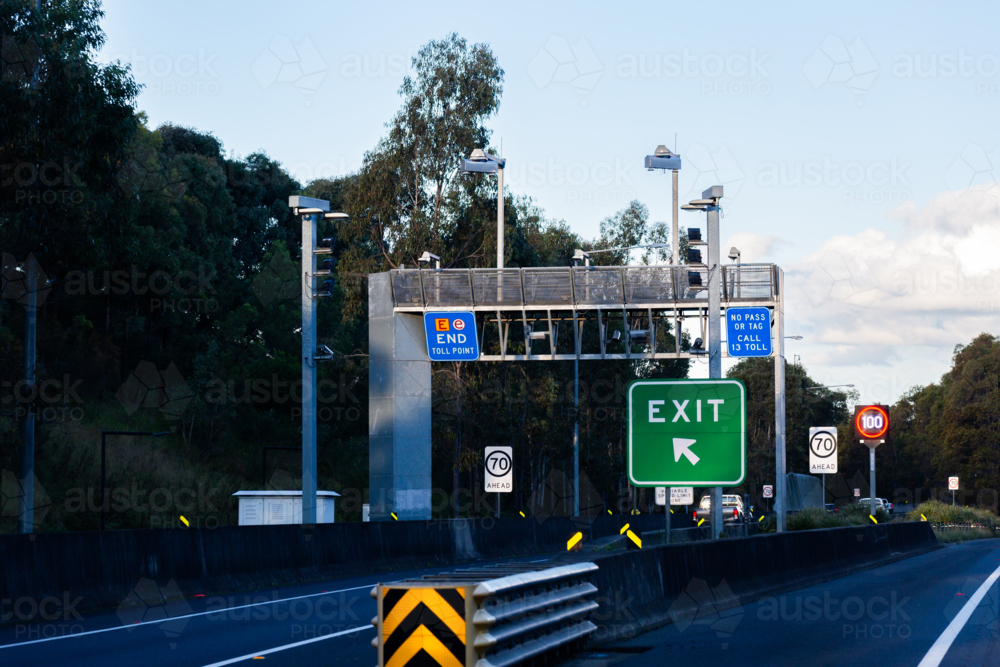 Exit sign beside tollway with end toll point road signs - Australian Stock Image