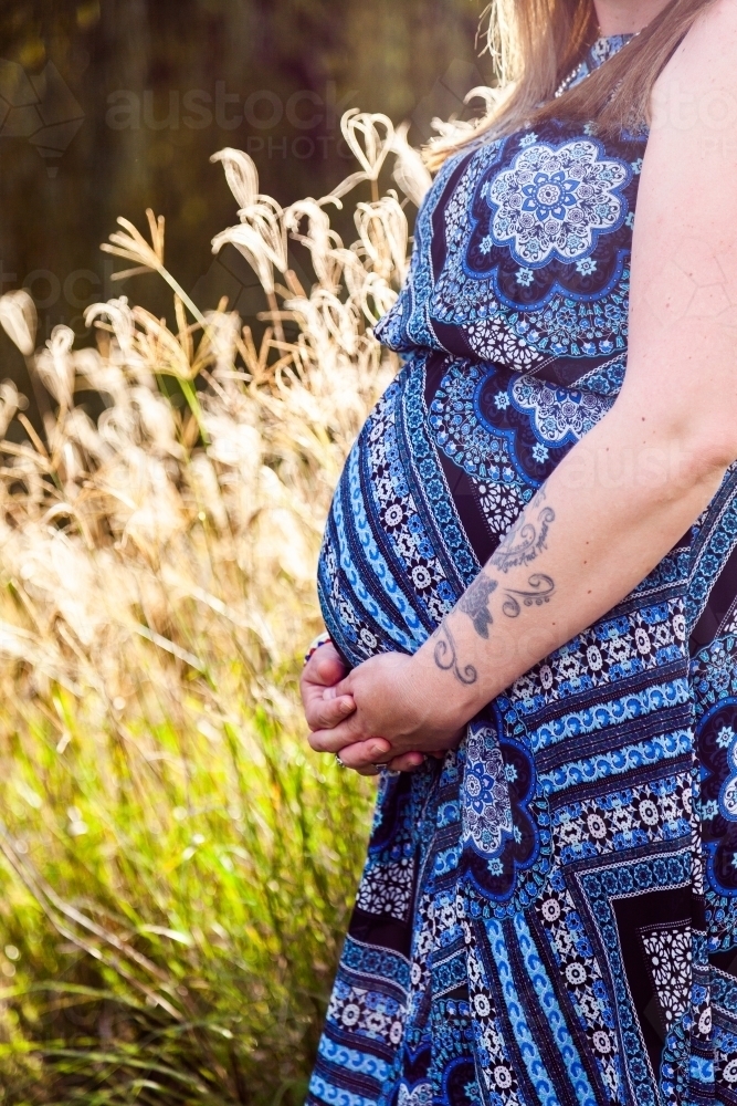 Expectant woman in blue dress - Australian Stock Image