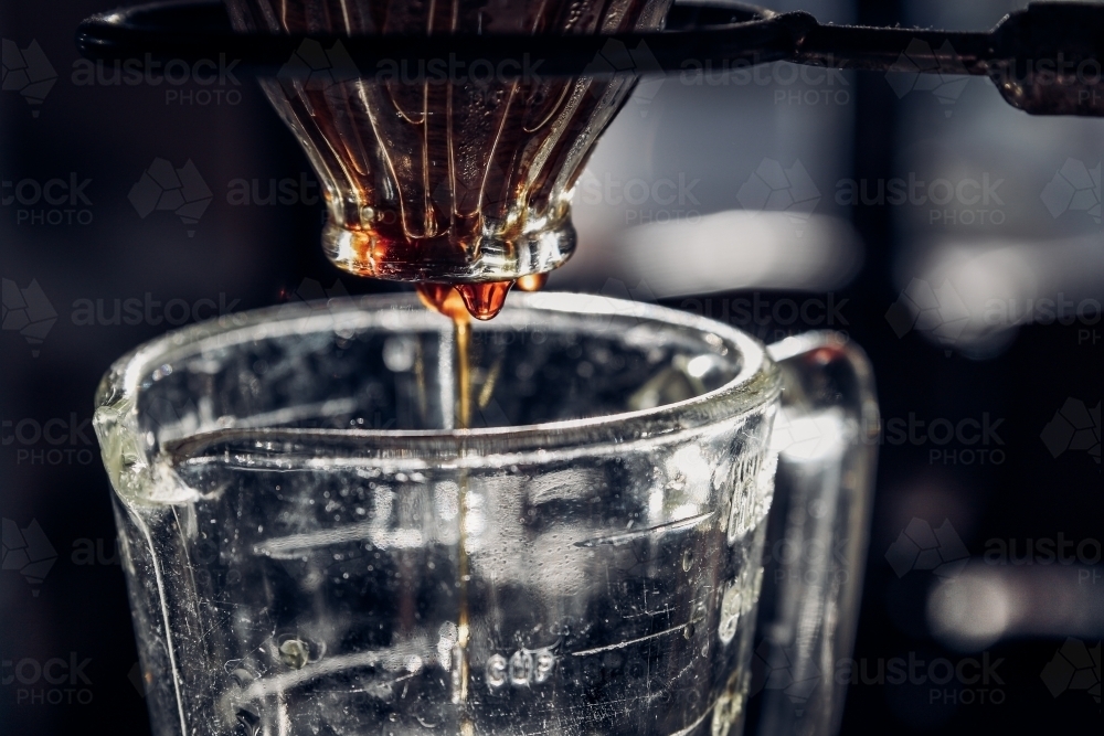 Extreme close up of coffee dripping through a V60 glass filter - Australian Stock Image