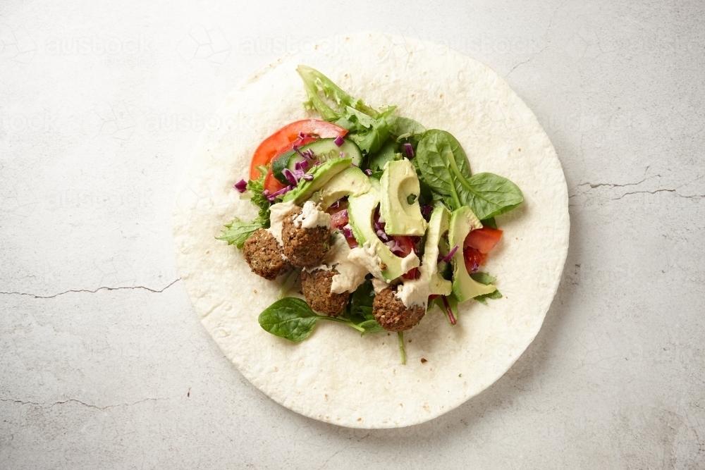 Falafel wraps with meatballs, vegetables, and dressing - Australian Stock Image