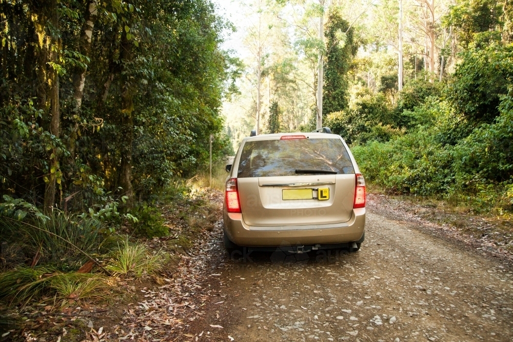 Family car on unsealed dirt country road with L plate - Australian Stock Image