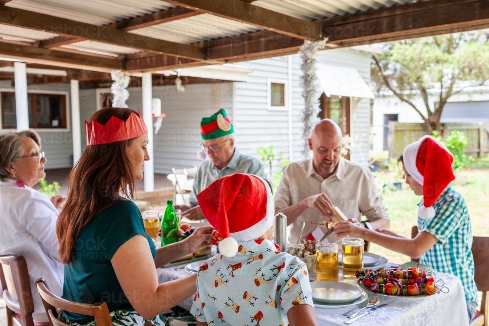 Image of Family cracking Christmas crackers together at Christmas lunch ...